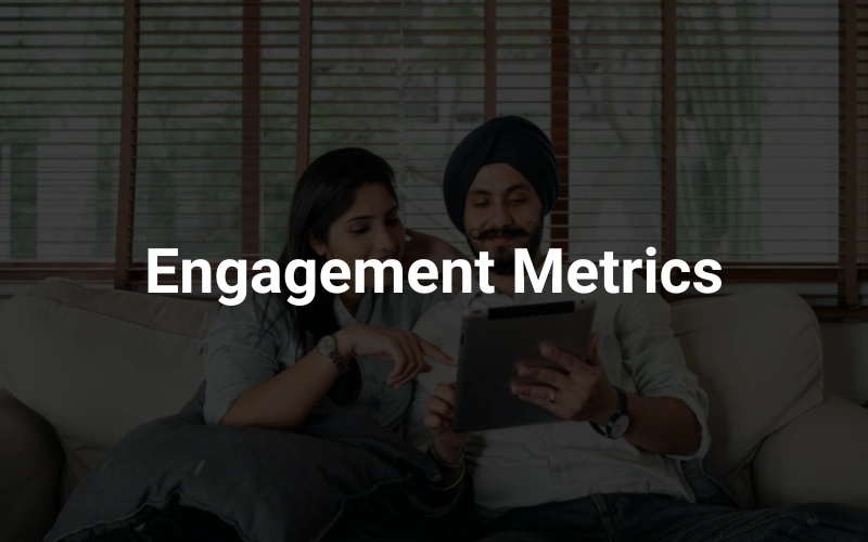 a man and woman sitting on a couch looking at a tablet in the background, highlighting the text "Engagement Metrics."