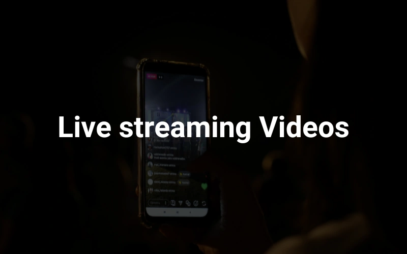 a person holding up a cell phone in the dark in the background, highlighting the text "Live streaming Videos."